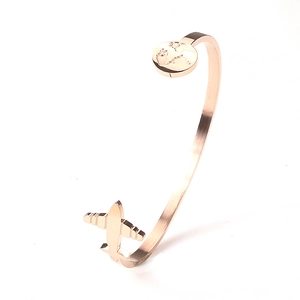Rose gold map and airplane titanium steel open bangle shown at a 45-degree angle