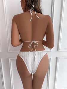 Detail of white textured bikini set showing halter tie back design on female model