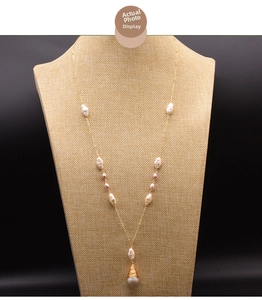 Macro view of gold baroque pearl necklace with purple beads on a textured linen stand