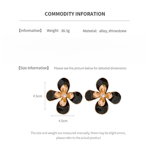 Detail showing vintage black enamel flower earrings with crystal center and alloy material