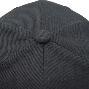 Vue macro du tissu en sergé de coton noir et du bouton supérieur d'une casquette baseball