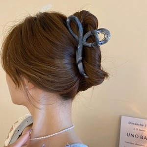 Detail of grey marble pattern hair claw clip on a French twist hairstyle