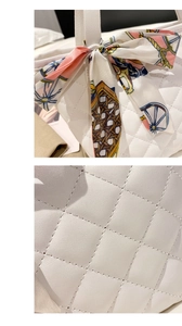 Detailed macro view of white quilted leather texture and patterned decorative silk scarf