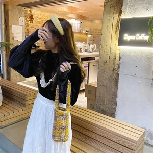 Plush checkered tote bag shown in a cozy cafe setting with autumn fashion accessories