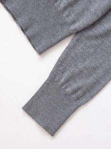 Detailed macro view of grey knit sweater cuffs featuring a premium ribbed weave texture