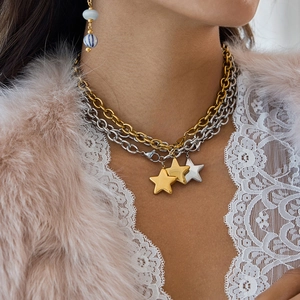 Star pendant layered necklace set in gold and silver finish worn by a model