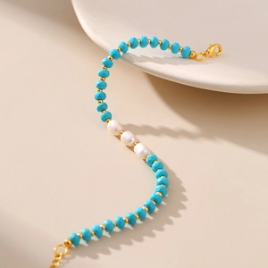 Detailed shot of turquoise faceted beads and freshwater pearls bracelet with gold clasp