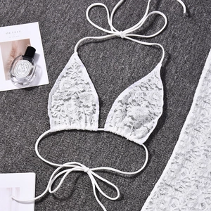 Detailed macro view of white lace crochet bikini top with elegant lace-up ties