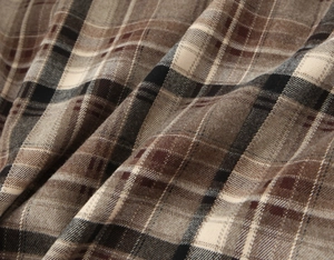 Gros plan du tissu en flanelle à carreaux marron et beige montrant sa texture douce