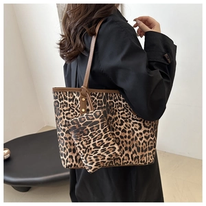 Leopard print tote bag with matching coin purse shown on model in a minimalist setting
