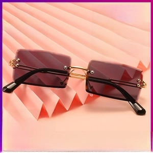 Macro detail of rimless rectangle gradient lenses and gold metal frames with bead accents