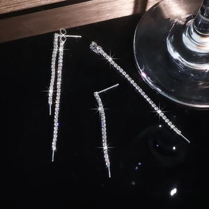 Macro detail of long silver fringe earrings with shimmering cubic zirconia stones