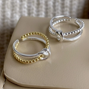 Macro shot of S925 sterling silver knotted rings highlighting the dual-layer design