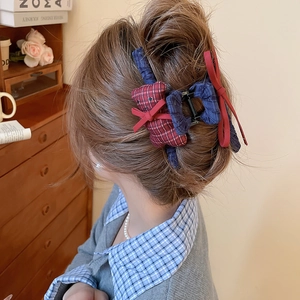 Detail of fabric hair claw clip with blue pleats and red plaid bear accessory