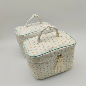 Quilted makeup bags with cherry and floral prints featuring blue trim and ribbon zippers