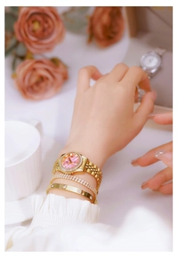 Close-up of elegant gold women's watch with pink dial and matching crystal bracelets