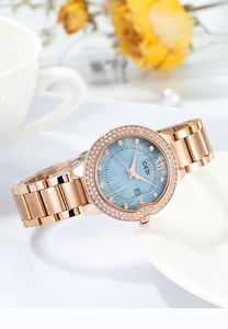 Detail of rose gold watch with blue mother of pearl dial and sparkling rhinestone bezel