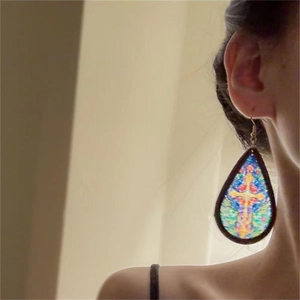 Bohemian acrylic teardrop earrings with stained glass cross pattern on a female model