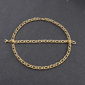 Polished gold stainless steel Figaro chain necklace for men on a dark textured background