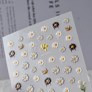Macro view of 5D embossed floral nail art stickers with daisies and honey bees