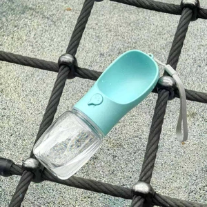 Close-up of portable pet water bottle with wide blue trough and transparent reservoir
