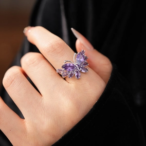 Détail d'une bague papillon en argent avec zircons violets portée par un mannequin