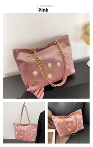 Pink velvet tote bag detail featuring gold sunflower rivets and metal chain strap