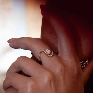 Elegant gold wave stainless steel ring with oval zircon on model's finger