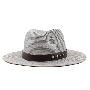 Vue détaillée du chapeau de paille gris avec ruban en cuir brun et rivets dorés