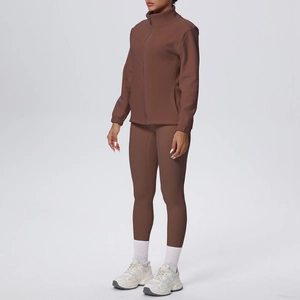 Dettaglio del set yoga marrone scuro con giacca con zip aderente e leggings abbinati