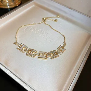 Détail du bracelet à maillons H dorés avec pierres de zircon et incrustations de nacre