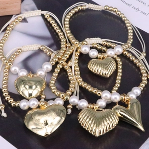 Handmade beaded bracelet with gold copper beads, white pearls, and heart charms