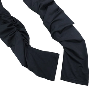 Vue détaillée du bas de pantalon froncé noir montrant la texture douce et le design plissé