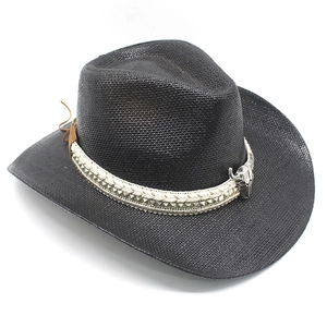 Detail of black straw cowboy hat featuring silver bull pendant and metallic studded band