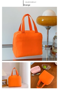 Macro detail of vibrant orange nylon insulated lunch bag with secure zipper and webbing handles