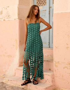 Detail of dark green hollow-out midi dress with sequin-like discs and fringe hem