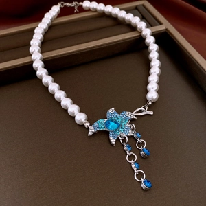 Detail of pearl necklace with blue starfish pendant and sparkling crystal accents
