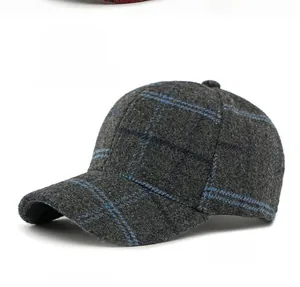 Close-up of wool plaid baseball cap in grey with blue check pattern and button detail