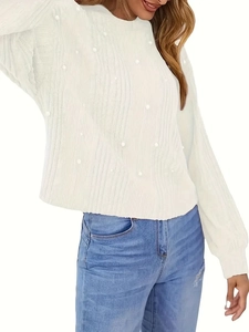 Détail d'un pull en maille blanc avec manches lanternes et ornements de perles élégantes