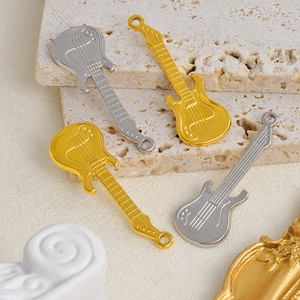 Close-up of four guitar-shaped pendants in gold and silver finish on stone bases