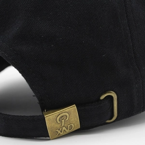 Détail de casquette de baseball noire en coton avec boucle de réglage en bronze antique