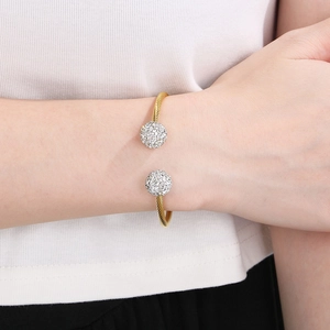 Detail of twisted cable gold bracelet with sparkling pavé crystal ball ends on wrist
