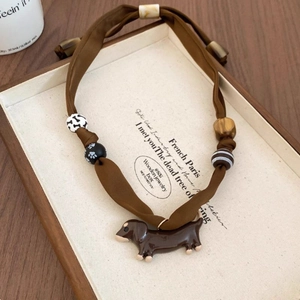 Detail of dachshund pendant necklace with fabric cord, bone beads and wooden charms
