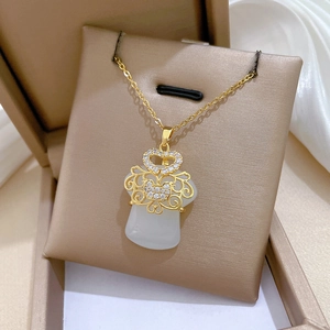 Close-up of golden Ruyi lock necklace with white faux jade inlay and sparkling crystals