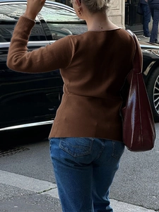 Street style view of the brown knit long sleeve top back detail with stylish shoulder bag