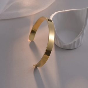 Détail macro d'un bracelet jonc en C en acier inoxydable doré à l'or 18 carats poli