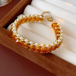 Detailed shot of vintage woven pearl bracelet with amber crystals and gold lobster clasp