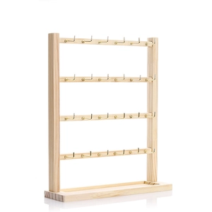 Detail view of 4-tier wooden earring display stand with 32 metal hooks on white background