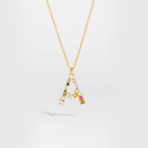 Detail of gold letter A pendant with colorful gemstones on a delicate chain necklace