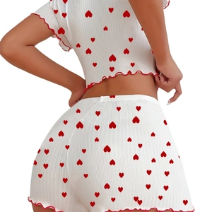 Detail of white ribbed knit pajama set with red heart pattern and lettuce edge trim